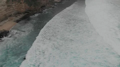 View of the turquoise long waves going to the beach and the view of mighty cliff Stock Footage 130839811