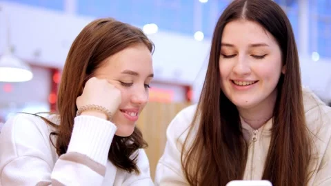 View to two beautiful young best girlfriends sitting and talking to each other Stock Footage 270314063