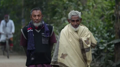 View of two elderly men walking along a rural path, Bangladesh. Video stock 335551019