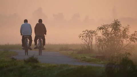 View of two men riding bicycles in misty Bogura, Bangladesh. Stock Footage 335588446