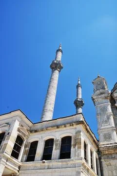 View of two minarets and a mosque. High minarets against the blue sky. Stock Photos