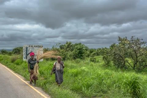 View of two old women loading farm tools and straw, along roadside, typical A Stock Photos