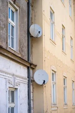 View of two satellite dishes installed on the wall of a residential building Stock Photos