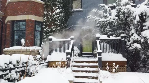 View of a two-story brick house with a porch and patio covered in snow. Vidéo 302566104