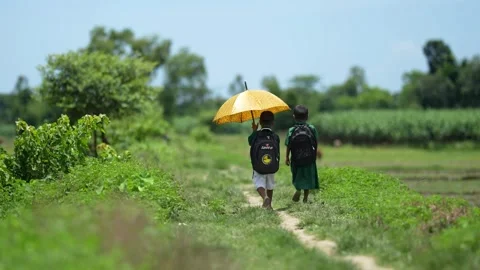 View of two students walking with a yellow umbrella, Bangladesh. Video stock 335585110