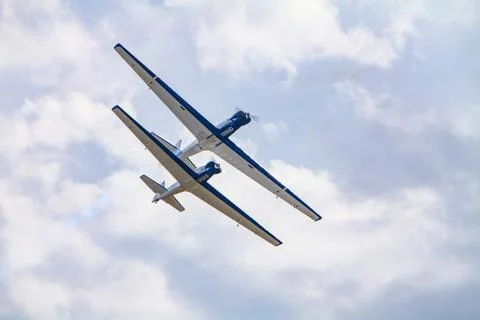 A view of two stunt planes flying overhead in close formation with one aircra 스톡 사진