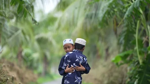 View of two young boys hugging on a path in Bogura, Bangladesh. 動画素材 334990949