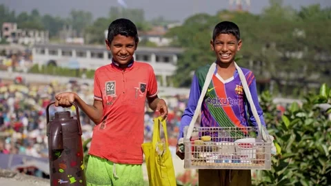 View of two young boys selling tea in a crowded market, Bangladesh. Video stock 335584430