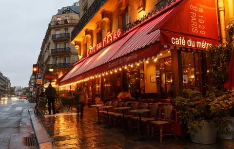 View of typical Parisian cafe du Metro at rainy night . It is located near fa Stock Photos