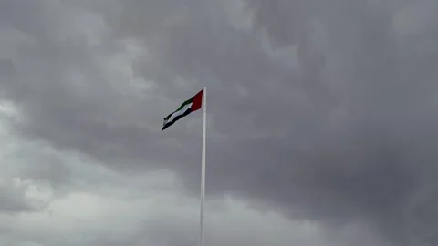 A view of the UAE national flag under overcast conditions in Sharjah. Video stock 332684373