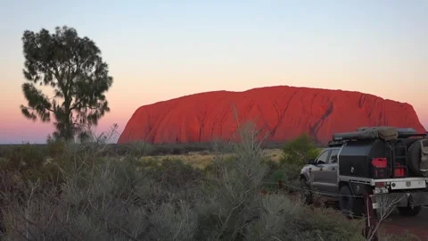 View of Uluru at sunset and parked off-road tourist vehicle in the foreground 스톡 동영상 278097689