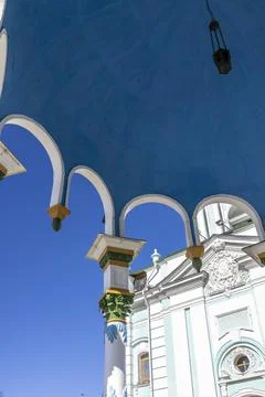 View from under the blue ceiling of the gazebo to the sky and the church Stock Photos