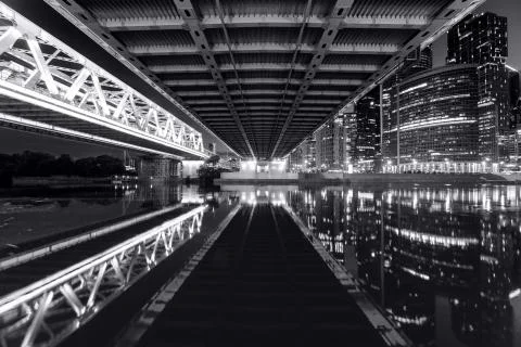 View from under the bridge to the river and the business center in the city Stock Photos