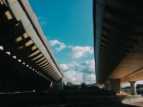 View under a concrete road bridge. bridge supports across the river Stock Photos