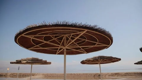 View from under a straw umbrella to the clear blue sky, on a sandy beach near Stock Footage 181646167