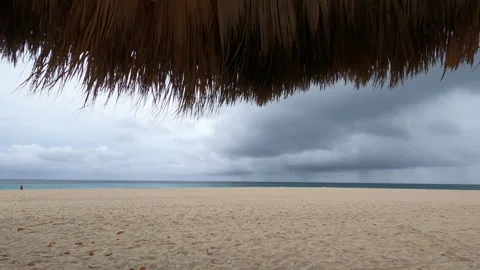 View from under an umbrella on the Caribbean beach on a cloudy day Stock Footage 261968446