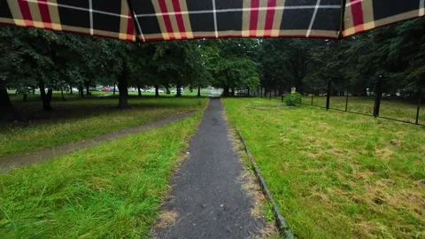 View from under an umbrella onto a dirt path, green lawns and trees. Stock Footage 316521171
