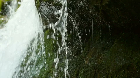 View under waterfall splash on stones in forest among mountains. Slow motion. Stock Footage 65541621
