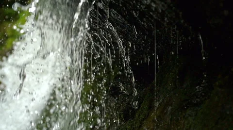 View under waterfall splash on stones in forest among mountains. Slow motion. Stock Footage 65542667