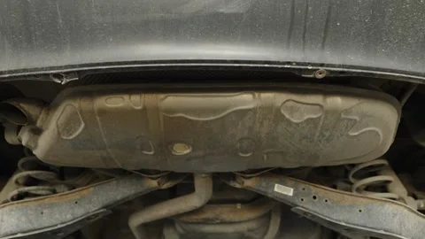 A view from underneath shows a car exhaust muffler and rear suspension Stock Footage 340154428