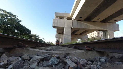 View from underneath a train toward the end of the train carrying people Stock Footage 120490800
