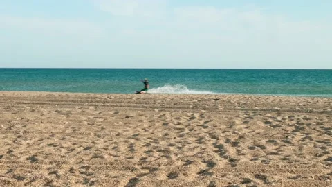 View of unrecognizable person doing kite surfing along the sea. Stock Footage 139870847