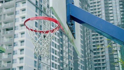 View of unrecognizable player throwing ball in a basketball hoop, the ball hits Stock Footage 239385875