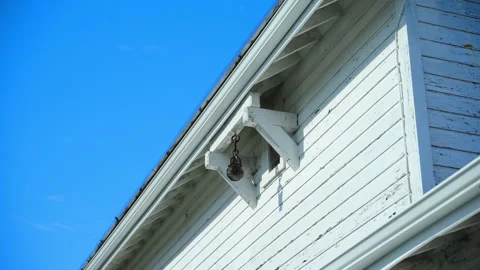 View of the upper section of an old white wooden barn with peeling paint. Rustic 動画素材 321116274