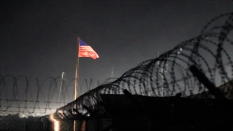 View of the US flag waving at night on a base camp in Afghanistan Stock-Footage 86295707
