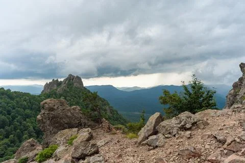 View of the valley from the height of the mountain range in a cloudy sky Stock Photos