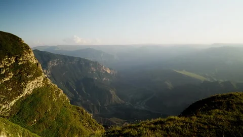A view of a valley from a mountain. Amidst the rugged highland terrain, a Stock Footage 256766067