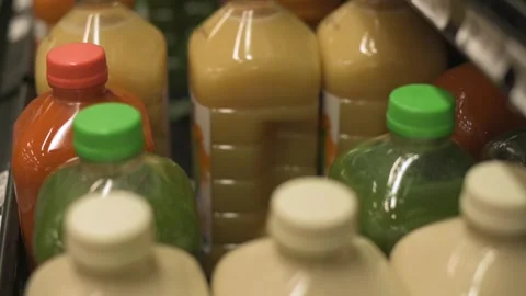 View of various bottled juices in a store fridge, featuring vibrant colors and 스톡 동영상 295838022