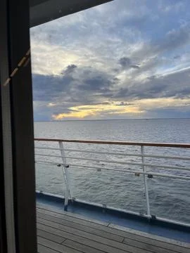 View of a vast ocean under a dramatic cloudy sky, with a hint of land on the Stock Photos