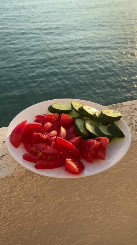 View of vegetables in a plate on the background of the sea 库存影片 183283442