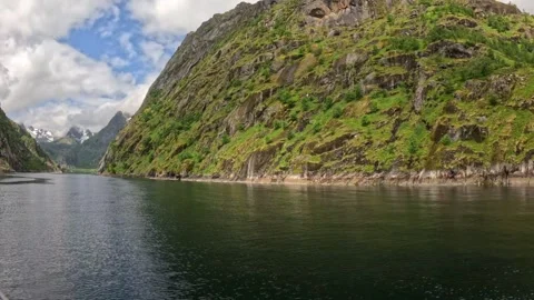 View of vessel sailing through serene Norwegian fjord under overcast sky Stock Footage 344753199