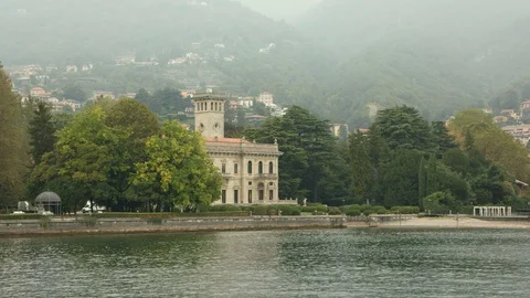View of Villa Erba on Lake Como amid Italian houses on a mountainside in haze Stock Footage 129043561