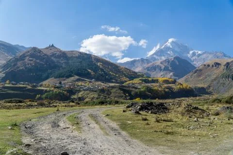 View of village Stepantsminda, Gergeti Trinity Church and mount Kazbek in Sunny Stock Photos