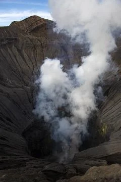 View into volcanic crater of active volcano Bromo with steam and smoke Photos