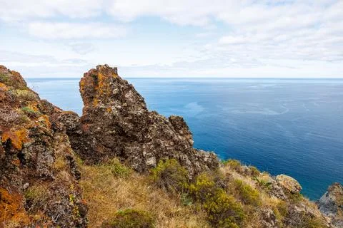 View of volcanic rocks covered with grass and the Atlantic Ocean, Madeira. Stock Photos