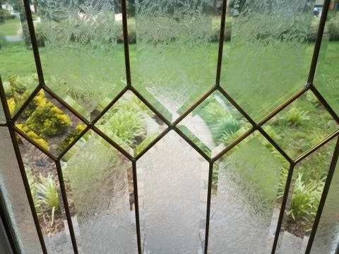 View of walkway and grass through glass front door Stock Photos
