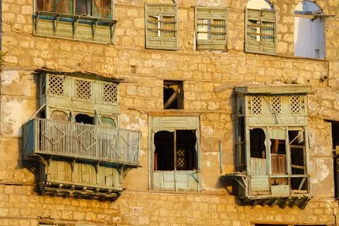 View of the wall of a house with broken dilapitated mashrabiya wooden balconies Stockfoto's