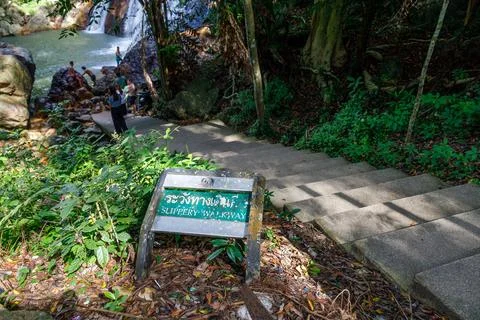 View of a warning sign about a slippery walkway near the Namuang Waterfall .. Stock Photos