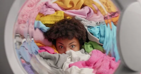 View from washing machine. Displeased Afro American woman sticks out head Stock Footage 156225809