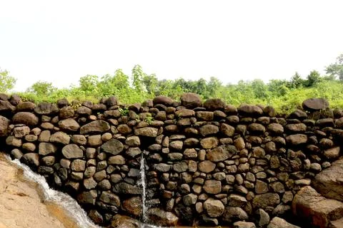 View of water falling from small stone wall Stock Photos