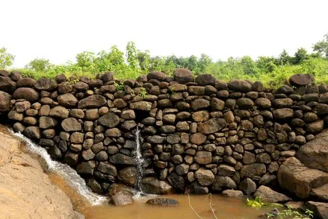 View of water falling from small stone wall Stock Photos