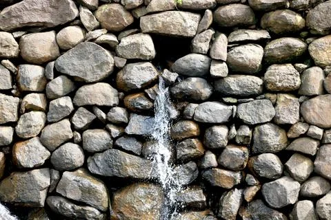 View of water falling from small stone wall Stock Photos