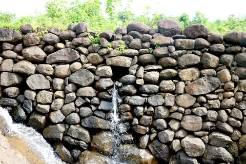 View of water falling from small stone wall Stock Photos
