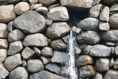View of water falling from small stone wall Stock Photos
