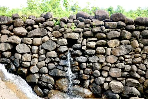 View of water falling from small stone wall Stock Photos