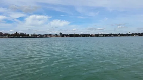 View from water on Lake Constance with Konstanz shoreline and mountains Stock Footage 333337117